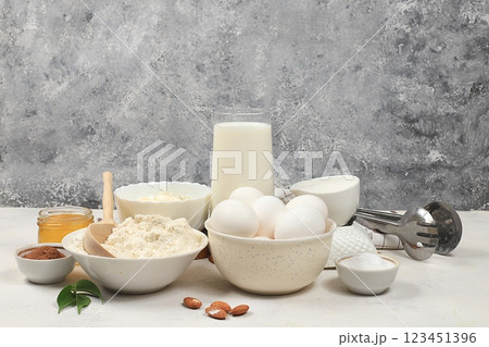 Kitchen background for baking and making cake,bread,confectionery and ingredients for cooking,milk,honey,flour,salt,sugar,eggs and cream on concrete background with place for text,selective focus, 123451396