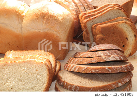 A loaf and slices of fresh bread on a sunny table. Healthy food and healthy ecological product. 123451909