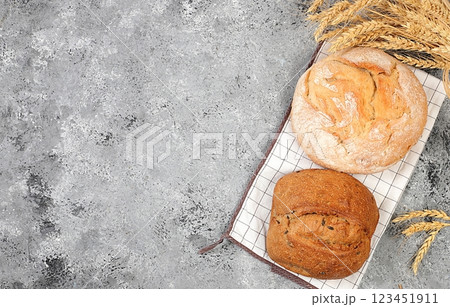 Freshly baked homemade bread, french sourdough baguette with crispy crust and ears of rye and wheat on concrete background with space for text, modern baking concept, healthy natural food, selective Freshly baked homemade bread, french sourdough baguette with crispy crust and ears of rye and wheat on concrete background with space for text, modern baking concept, healthy natural food, selective 123451911