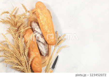 Freshly baked homemade bread, french sourdough baguette with crispy crust and ears of rye and wheat on old concrete background with space for text, modern bakery concept, healthy natural food, 123452072