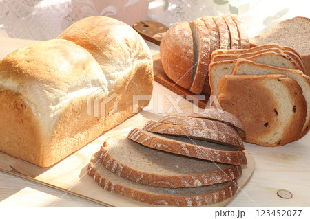 A loaf and slices of fresh bread on a sunny table. Healthy food and healthy ecological product. 123452077