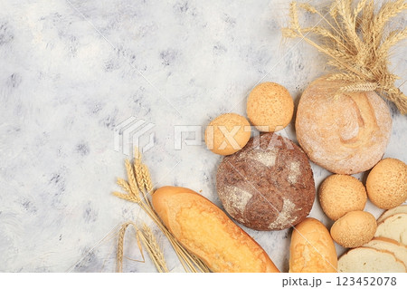Assortment of homemade sourdough bread with crispy crust and ears of rye and wheat on gray concrete background with place for text, modern bakery concept, top view, healthy natural food, selective 123452078