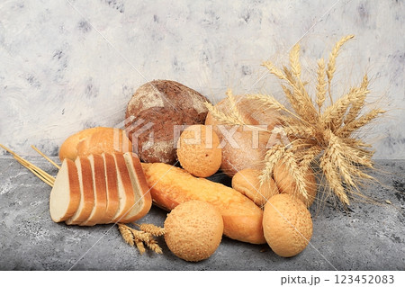Assortment of homemade sourdough bread with crispy crust and ears of rye and wheat on gray concrete background with place for text, modern bakery concept, top view, healthy natural food, selective 123452083