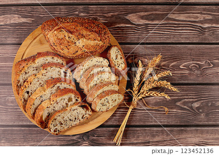 Sliced freshly baked whole grain homemade sourdough bread with crispy crust and sprouting wheat on wooden table, modern baking concept, healthy natural food Sliced freshly baked whole grain homemade sourdough bread with crispy crust and sprouting wheat on wooden table, modern baking concept, healthy natural food 123452136