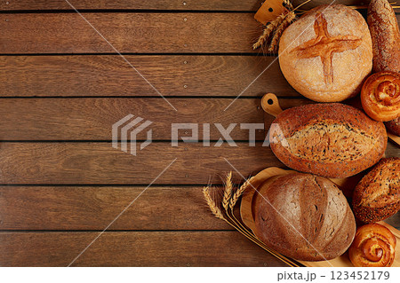 Freshly baked bakery products, whole grain homemade bread, different types of round sourdough bread with crispy crust, baguettes, buns and ears of wheat on wooden background, modern baking concept Freshly baked bakery products, whole grain homemade bread, different types of round sourdough bread with crispy crust, baguettes, buns and ears of wheat on wooden background, modern baking concept 123452179