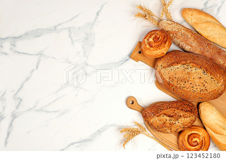 Freshly baked whole grain homemade bread, different types of round sourdough bread with crispy crust, baguettes, buns and ears of wheat on marble background, modern baking concept, Freshly baked whole grain homemade bread, different types of round sourdough bread with crispy crust, baguettes, buns and ears of wheat on marble background, modern baking concept, 123452180