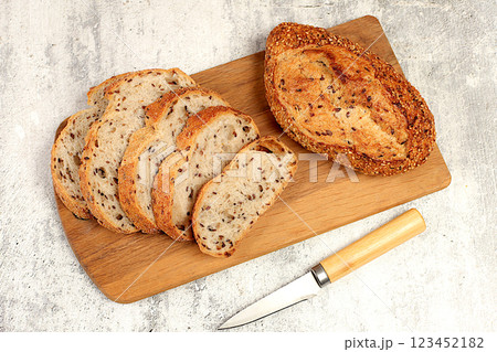 Freshly baked whole grain homemade sourdough bread with crispy crust, sliced and ears of wheat on concrete table, modern baking concept, healthy natural food Freshly baked whole grain homemade sourdough bread with crispy crust, sliced and ears of wheat on concrete table, modern baking concept, healthy natural food 123452182