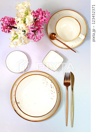 Cutlery with flowers on a plate on a marble background. Elegant festive table setting, menu layout in a cafe or restaurant, festive composition with a bouquet of hyacinths, kitchen background. Cutlery with flowers on a plate on a marble background. Elegant festive table setting, menu layout in a cafe or restaurant, festive composition with a bouquet of hyacinths, kitchen background. 123452371