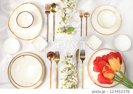 Elegant festive table setting, menu design in a cafe or restaurant for congratulations, festive composition with a bouquet of tulips and cherries, cutlery with flowers on a plate, beautiful kitchen 123452376
