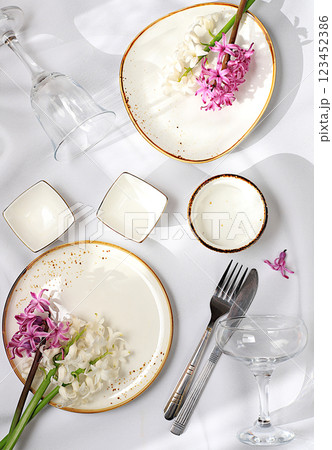 Elegant festive table setting, menu layout in a cafe or restaurant, cutlery with flowers on a plate on a marble background, festive composition with a bouquet of hyacinths, kitchen background. 123452386