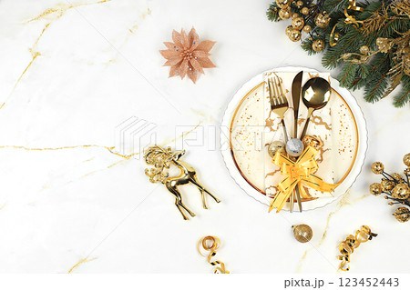 Christmas table setting, holiday menu layout, New Year's cutlery with napkin on a plate on a marble concrete background, festive composition with fir branches, kitchen background. Selective focus 123452443