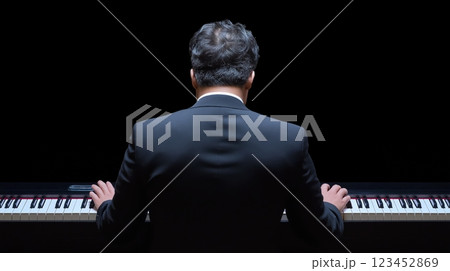 Musician plays piano in a dark setting during an emotional performance 123452869