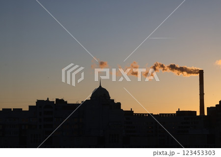 An Industrial Sunset Silhouette Periodically Featuring Smoke Emission Against the Horizon 123453303