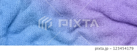A soft and textured gradient blue and purple knitted fabric with gentle waves and folds, creating a cozy and warm appearance. Ideal for textile backgrounds, fashion, or home decor themes. A soft and textured gradient blue and purple knitted fabric with gentle waves and folds, creating a cozy and warm appearance. Ideal for textile backgrounds, fashion, or home decor themes. 123454179