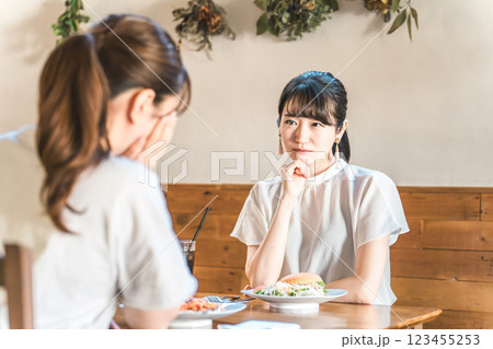カフェでランチをしながら悩み相談を友達にする若いアジア人女性 123455253