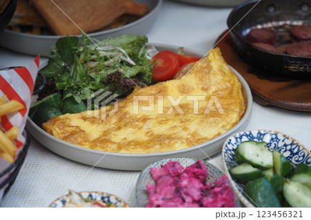A hearty omelette alongside a vibrant salad and sliced vegetables A hearty omelette alongside a vibrant salad and sliced vegetables 123456321