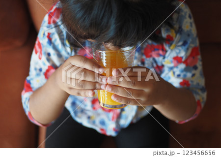Child enjoying a refreshing drink while sitting on a couch 123456656