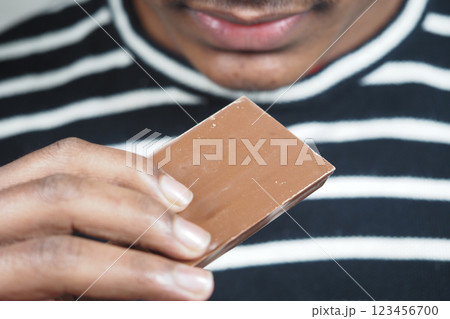 Sweet anticipation of chocolate treat held close to lips Sweet anticipation of chocolate treat held close to lips 123456700