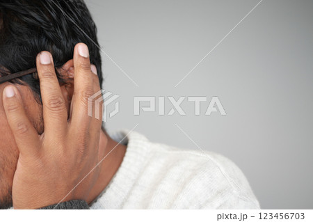 Man covering ears while experiencing loud noise in quiet room 123456703