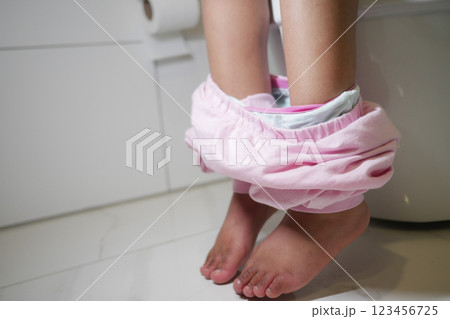 Child in pink pants using the toilet in a modern bathroom setting 123456725