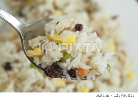 Colorful rice dish garnished with peas, corn, and raisins 123456815