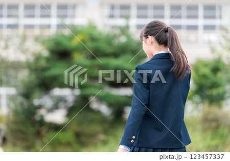 学校の校舎の前に立つ制服姿の中学生・高校生・小学生の後ろ姿 学校の校舎の前に立つ制服姿の中学生・高校生・小学生の後ろ姿 123457337
