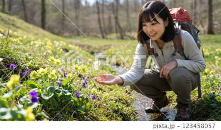 春のハイキングを楽しむ女性と蝶と花 123458057