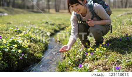 春のハイキングを楽しむ女性と蝶と花 123458058