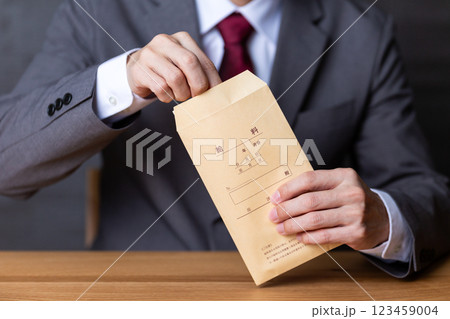 グレーのスーツを着て給料袋を持つミドル男性ビジネスマン 123459004