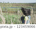 Half turn woman with flying hair in blooming lavender field looking at sunset. 123459066