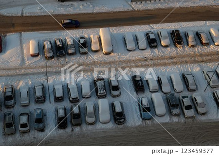 An Aerial View Capturing a SnowCovered Parking Lot Featuring Various Vehicles Positioned An Aerial View Capturing a SnowCovered Parking Lot Featuring Various Vehicles Positioned 123459377