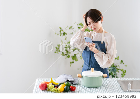 エプロン姿で料理する若い女性　ライフスタイルイメージ	 123459992