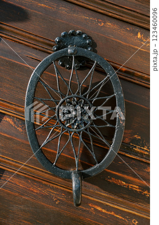 Antique openwork metal handle on a wooden door. Close-up 123460096