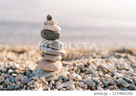 Cairn stands casting a shadow on a pebble beach in the sun Cairn stands casting a shadow on a pebble beach in the sun 123460160
