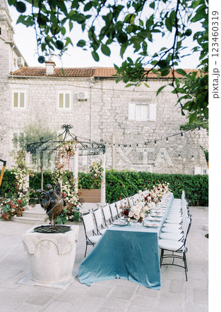 Laid long table with chairs stands in the garden near the wedding rotunda Laid long table with chairs stands in the garden near the wedding rotunda 123460319