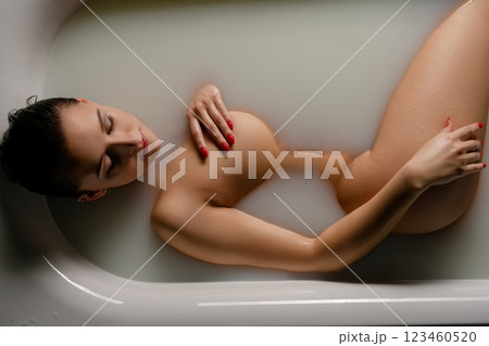 Woman in a bath embracing beauty and body art while relaxing in serene waters Woman in a bath embracing beauty and body art while relaxing in serene waters 123460520