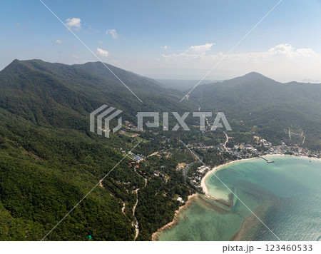 Small town nestled between lush green hills and turquoise ocean waters, with roads and beaches visible. Ko Pha Ngan, Thailand. Small town nestled between lush green hills and turquoise ocean waters, with roads and beaches visible. Ko Pha Ngan, Thailand. 123460533