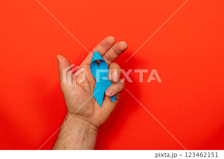 Support for cancer awareness through symbolic blue ribbon and hand gesture 123462151