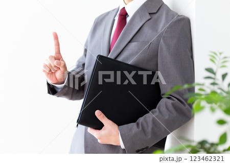 グレーのスーツを着て資料を持つミドル男性ビジネスマン 123462321