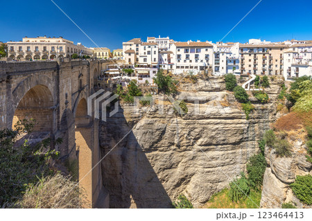 The Puente Nuevo bridge in El Tajo gorge in Ronda town in Spain. Ancient stone bridge spanning a deep gorge, overlooking a picturesque town of white buildings. 123464413