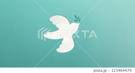 Peace and New Beginnings of Hope. A white dove Flying with an Olive Branch. World International Peace Day. The Concept of a Fluttering Bird that brings Peaceful to the World, Made from Paper 123464479
