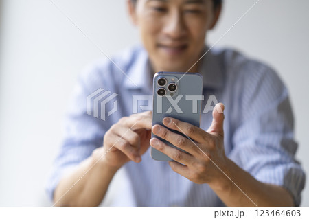 スマートフォンを操作する40代の男性の手元 123464603