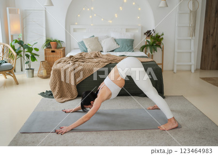 Yoga fitness workout training. Woman practicing yoga at home. Woman doing sports exercise on yoga mat on floor indoor. Girl in sportswear have training workout for weight loss. Sport and fitness Yoga fitness workout training. Woman practicing yoga at home. Woman doing sports exercise on yoga mat on floor indoor. Girl in sportswear have training workout for weight loss. Sport and fitness 123464983