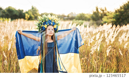 Girl blue and yellow flag of Ukraine in field. Ukraine's Independence Flag Day. Constitution day. 24 August. Patriotic holiday. 123465517