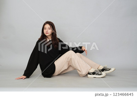 Young girl posing in a versatile black hoodie, a staple for any casual or streetwear-inspired teen wardrobe. Young girl posing in a versatile black hoodie, a staple for any casual or streetwear-inspired teen wardrobe. 123466645