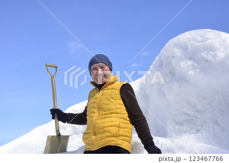 雪の山をスコップで排雪している老人 123467766
