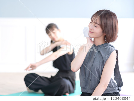 汗拭きタオルで汗を拭く若い女性 123468044