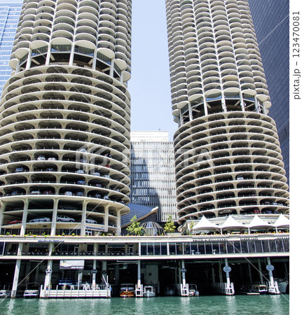 Unique Architectural Design of Twin Towers by the Water in Chicago with boats docked and cars parked underneath 123470081