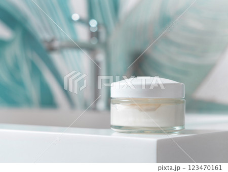 Cream jar on wash basin in green tropical bathroom close up, cosmetic mockup for facecare product 123470161