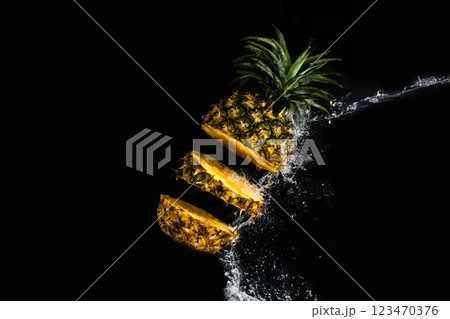 Pineapple is cut into slices, creating a dynamic splash as water streams around it. 123470376